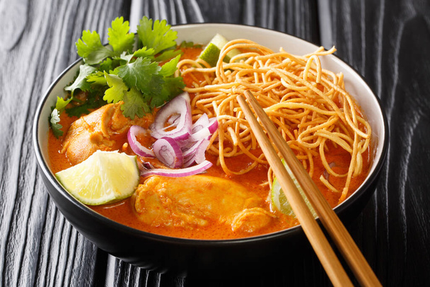 Pollo khao soi thai coco curry sopa de fideos primer plano en el tazón en la mesa. Horizonta - Foto, Imagen