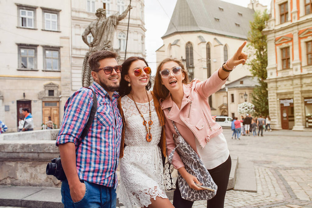 jong hipster bedrijf van vrienden reizen, vintage stijl, Europa vakantie, zonnebril, oude stad centrum, gelukkig positieve stemming, glimlachen, omarmen, wijzende vinger, kijken vooruit - Foto, afbeelding