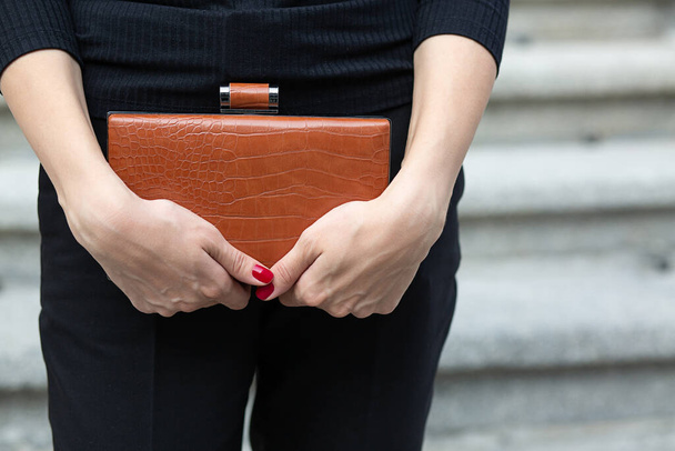 レザーブラウンのバッグを持っている女性の手のクローズアップショット - 写真・画像