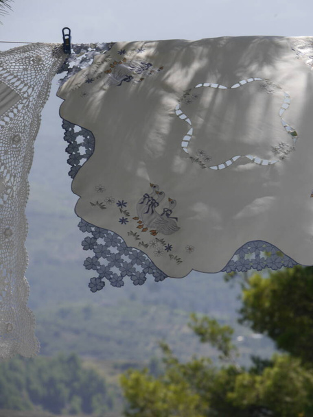 Close up de guardanapos bordados à mão na linha de lavagem soprando no vento na Albânia rural, Balcãs. Foto de alta qualidade - Foto, Imagem