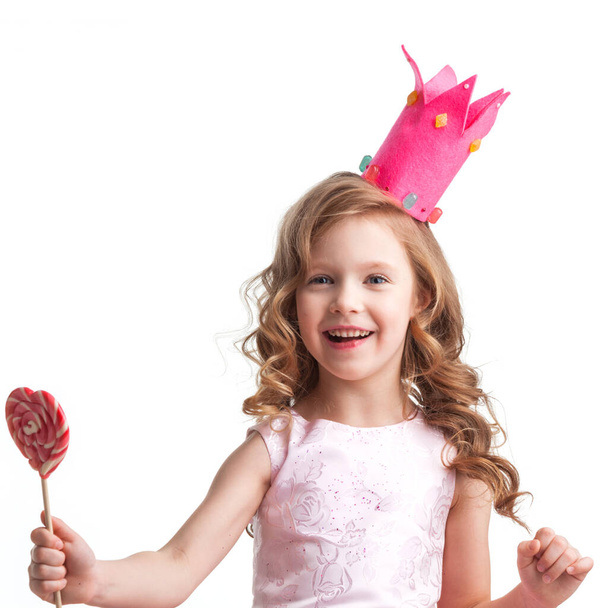 Beautiful little candy princess girl in crown with big pink heart lollipop - Fotó, kép