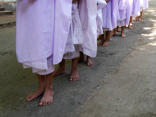 Közelkép egy sor kezdő apáca lábáról orgona köntösben, Mianmar - Fotó, kép