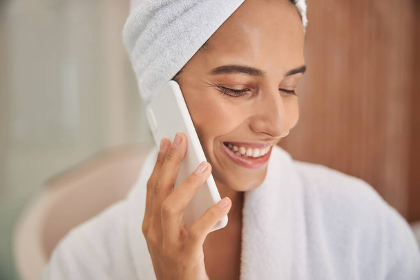 Giovane donna allegra che parla sul cellulare dopo la doccia - Foto, immagini