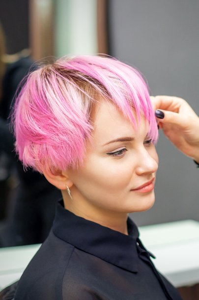 Jeune femme recevant coiffure rose courte par coiffeuse dans un salon de beauté - Photo, image