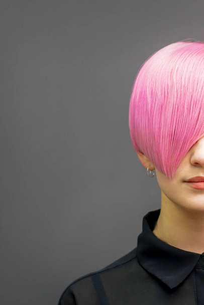 Retrato de una hermosa mujer caucásica joven con el pelo corto de color rosa brillante. Colorante de pelo profesional - Foto, imagen