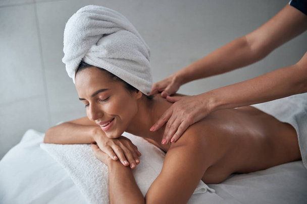 Руки масажу масажують молоду жінку назад у спа-салоні. - Фото, зображення