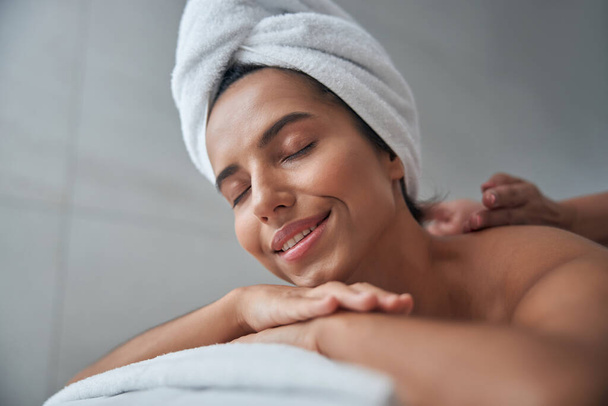 Beautiful young woman enjoying massage in spa salon - Фото, зображення