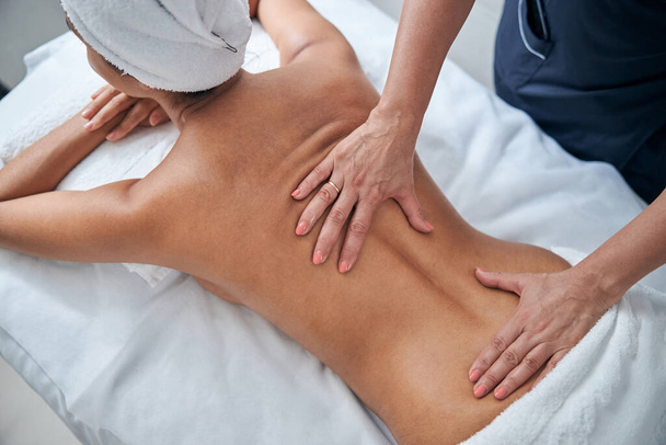Masseur mãos massagear jovem mulher de volta no salão de spa - Foto, Imagem
