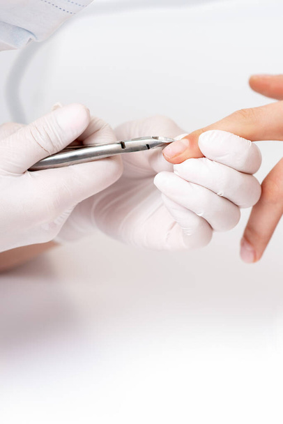 Detailní záběr manikúra pomocí manikúra řezačka k odstranění kůžičky ženských nehtů v manikúře salon - Fotografie, Obrázek