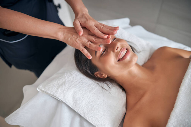 Masseur mains massant visage féminin dans le salon de spa - Photo, image