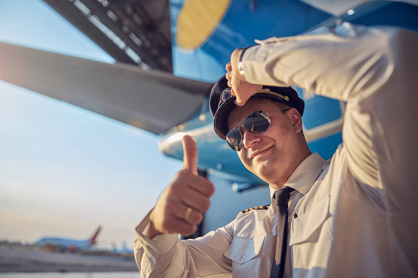 Magabiztos légi kapitány mutatja, mint miközben áll a szabadban - Fotó, kép