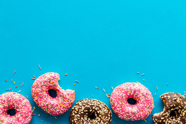 Donuts flat lay pattern on blue background, top view - 写真・画像