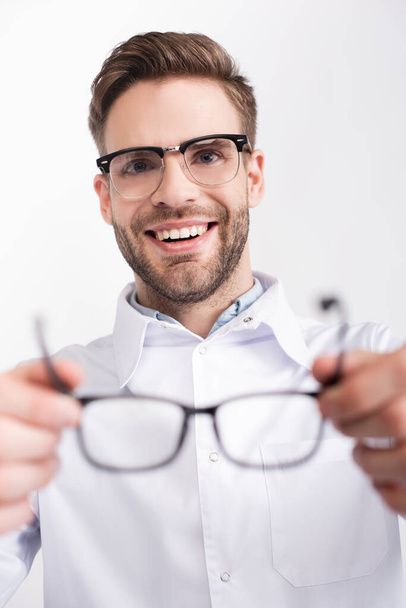 oftalmólogo feliz poner gafas aisladas en blanco en primer plano borrosa - Foto, imagen