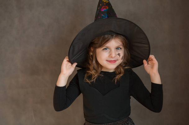 Маленька дівчинка в костюмі Хеллоуїна відьми з павутиною і ближче на її обличчі
 - Фото, зображення