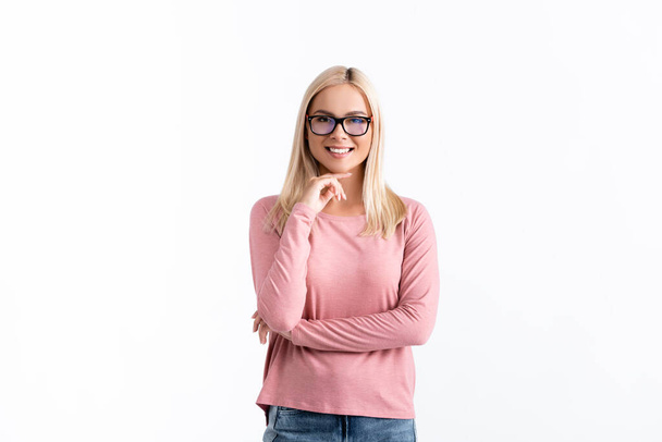 Blonde woman in eyeglasses with hand near chin looking at camera isolated on white - Foto, Imagem