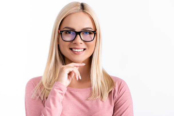 Smiling woman in eyeglasses with hand near chin looking at camera isolated on white - Foto, Bild