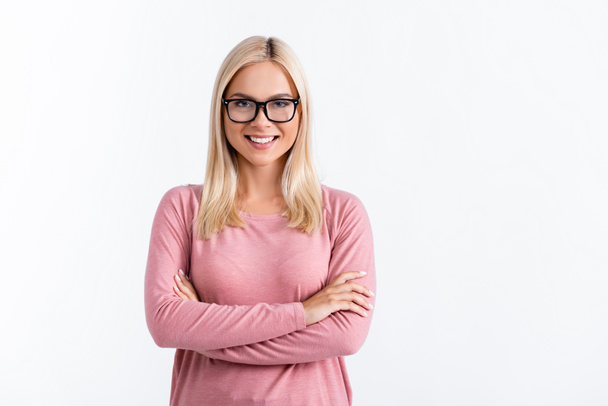 Cheerful woman in eyeglasses with crossed arms looking at camera isolated on white - Zdjęcie, obraz