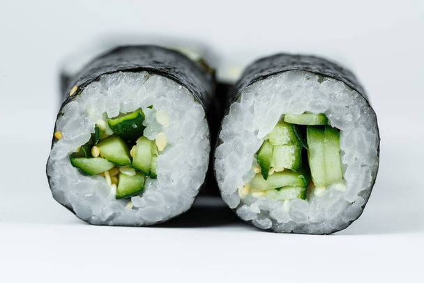 Japans eten. Rollen met rijpe komkommer, verse rijst met groenten in nori. Vegetarische broodjes - Foto, afbeelding