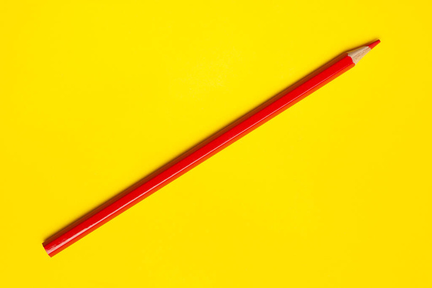 diagonal red sharp wooden pencil on a bright yellow background, isolated, copy space, mock up - Valokuva, kuva