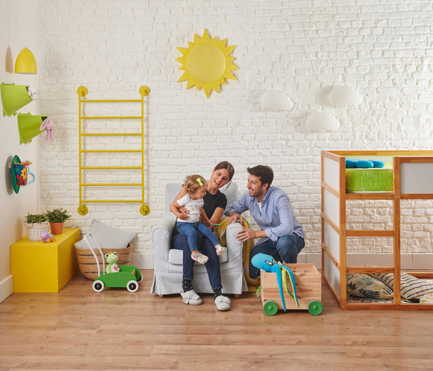 Modern baby room interior style, white brick wall yellow sun and cloud, armchair, family looking for child and happy. - Фото, изображение