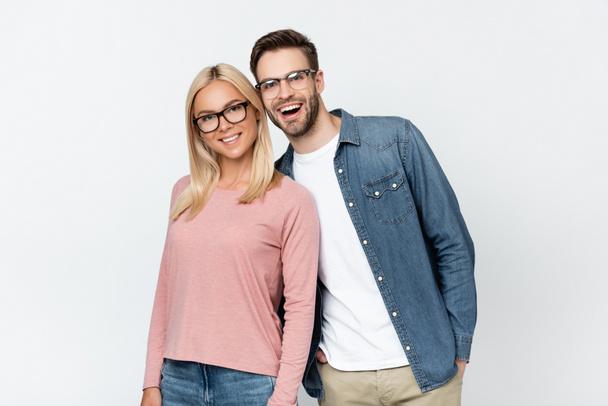 Cheerful couple in eyeglasses looking at camera isolated on grey - Fotografie, Obrázek
