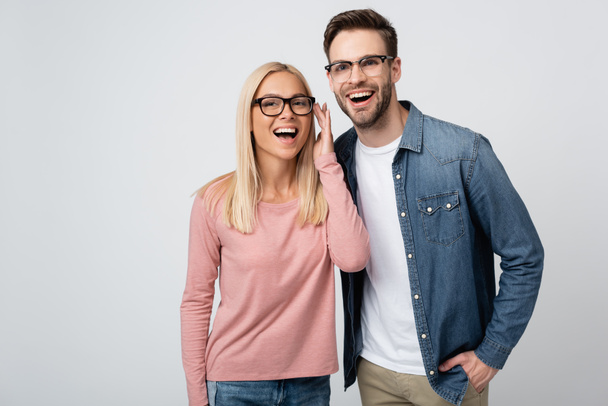 Smiling couple in eyeglasses standing isolated on grey - Valokuva, kuva
