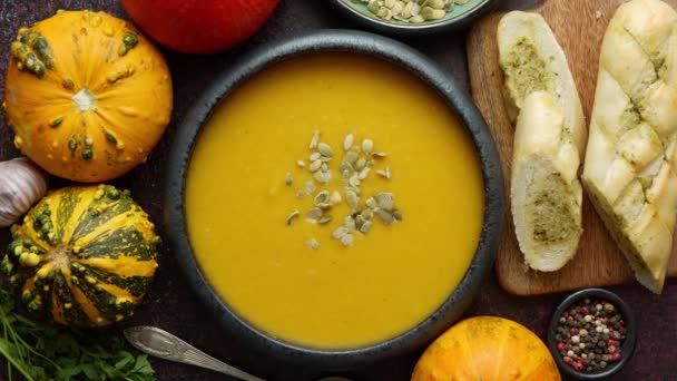 Házi készítésű vegetáriánus sütőtök krém leves kerámia tálban. Maggal díszítve - Felvétel, videó