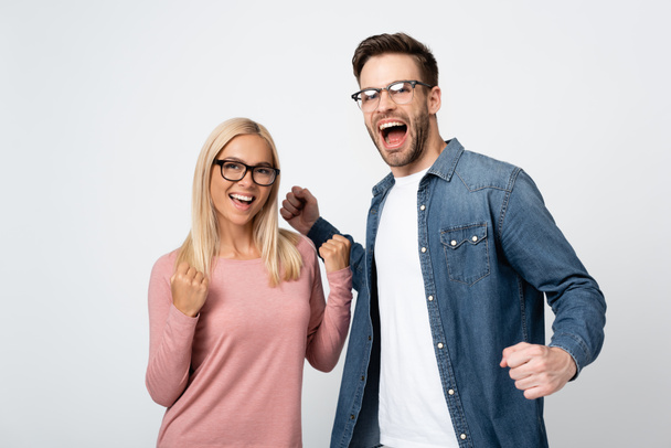 Vzrušený pár v brýlích ukazující jo gesto izolované na šedi - Fotografie, Obrázek