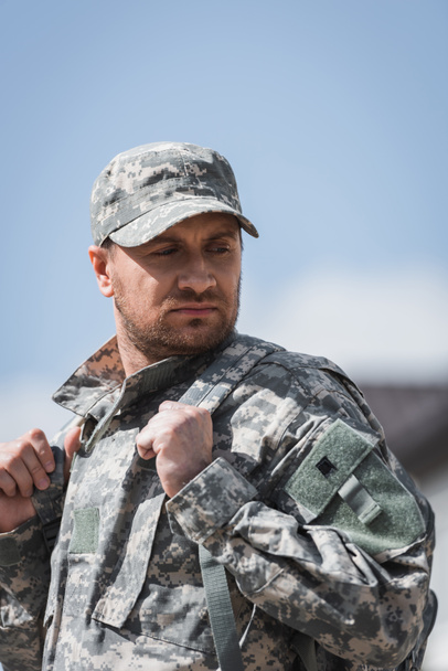 Serious military serviceman looking away on blurred background - Фото, зображення