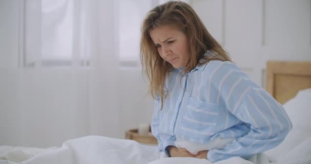 Stomachache. The redhead girl has awful stomachache at her home. Abdominal pain. Her menstrual cramps are too painful to go to work - Footage, Video