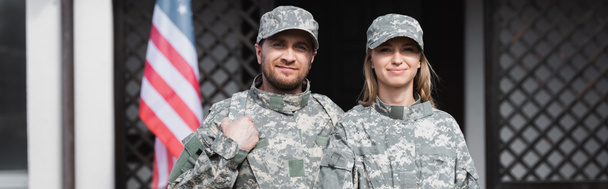 Lächelndes Militärpaar blickt in die Kamera auf verschwommenem Hintergrund, Banner - Foto, Bild