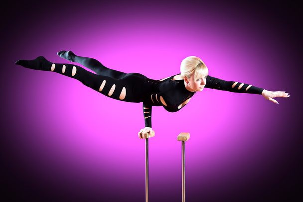 circus actor standing on the hand on a purple background - Zdjęcie, obraz