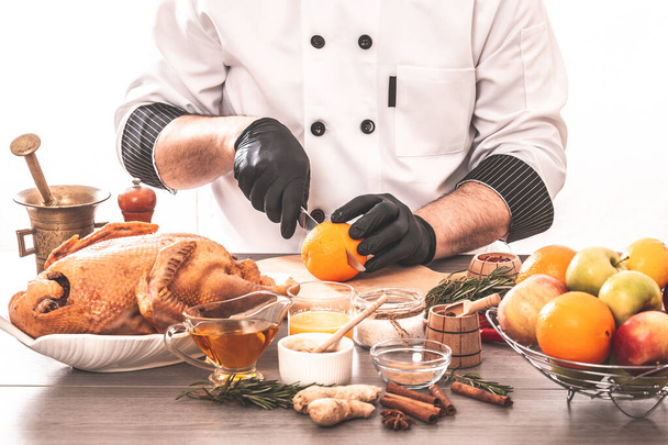 Koken chef-kok eend koken gevulde eend met sinaasappels en appels, vakantie menu concept. - Foto, afbeelding