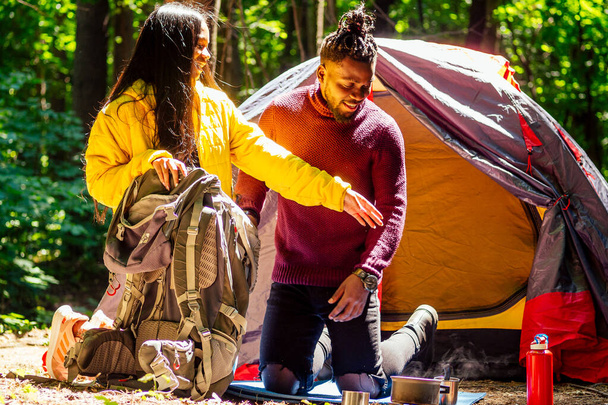 afro american mixed race couple establishing installation a tent and having a rest time outdoors - Foto, Bild