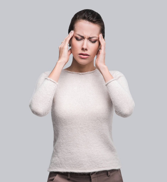 Young beautiful woman has headache, isolated on gray background - Photo, image