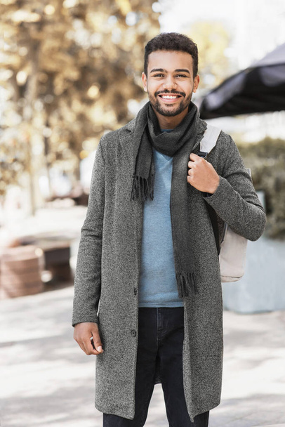Handsome joyful man autumn portrait. Smiling men student wearing warm clothes in a city in winter - Фото, зображення