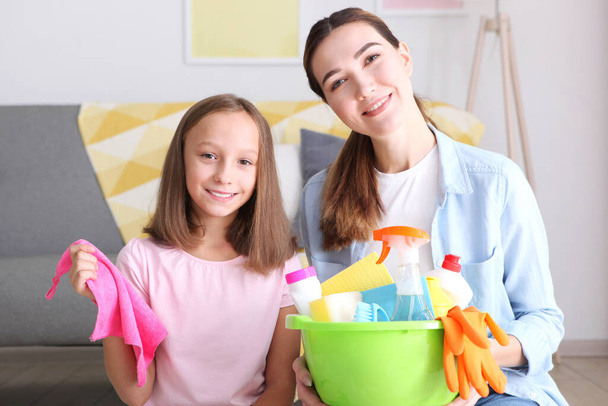 Madre e hija de buen humor están limpiando la casa con desinfectantes y detergentes - Foto, imagen