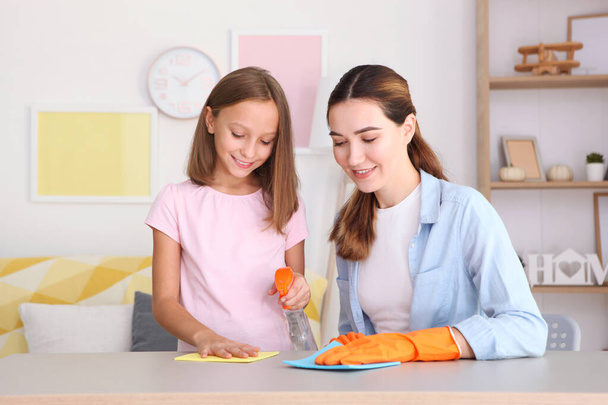 Madre e figlia di buon umore puliscono la casa con disinfettanti e detergenti - Foto, immagini
