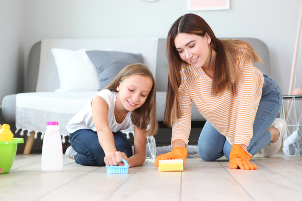 Mother and daughter in a good mood are cleaning the house with disinfectants and detergents - Zdjęcie, obraz