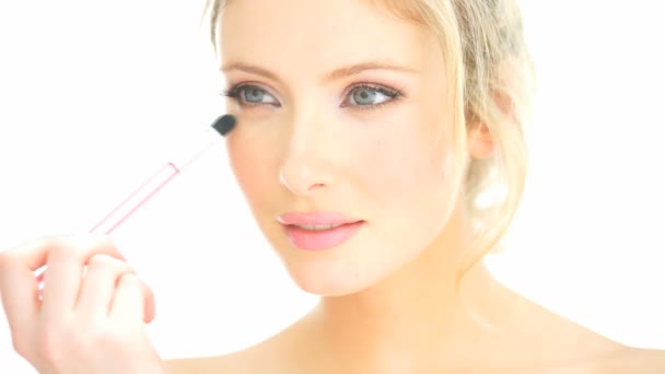 Mujer rubia aplicando su maquillaje
 - Metraje, vídeo