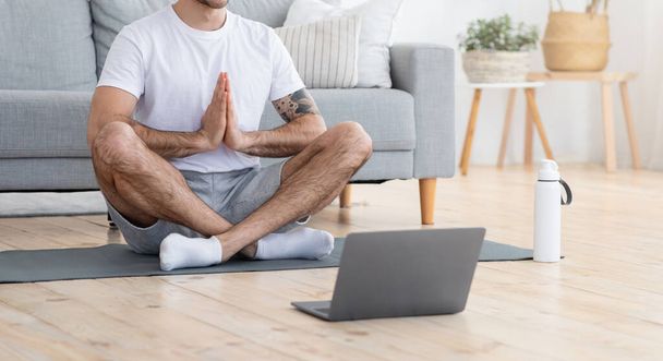 Meditující muž sedící na podlaze před laptopem - Fotografie, Obrázek