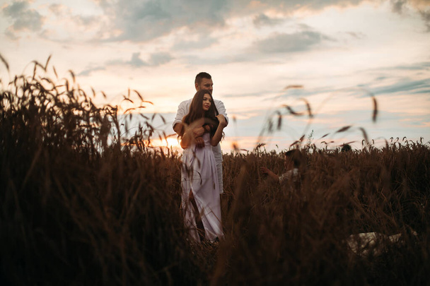 Beautiful couple standing in the field. - Φωτογραφία, εικόνα