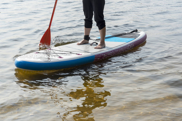Standup paddleboarding are on the river Moscow, Strogino. The concept of a healthy lifestyle. - Photo, Image