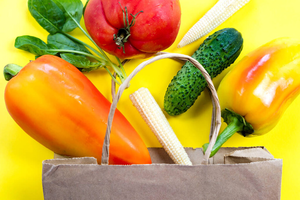 Konzept der natürlichen Bio-Rohkost-Lieferung aus dem Lebensmittelladen, Entgiftung ausgewogener gesunder Lebensmittel, Gemüse in Papiertüte auf gelbem Blick von oben, umweltfreundliche Gemüseflachlage - Foto, Bild