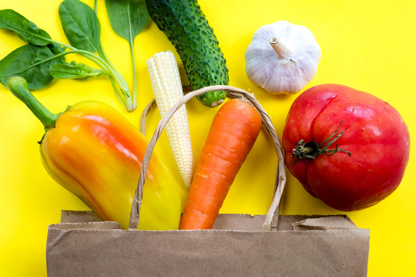 Koncept přirozené ekologické dodávky syrové zeleniny z obchodu s potravinami, detox vyvážené zdravé potraviny, zelenina v papírovém sáčku na žlutém výhledu shora, ekologicky šetrný zeleninový byt ležel - Fotografie, Obrázek