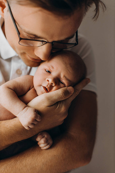 Caring father with adorable newborn baby girl, handsome dad hold in arms beautiful little daughter, enjoy happy parenting moments, smiling, fatherhood concept - 写真・画像