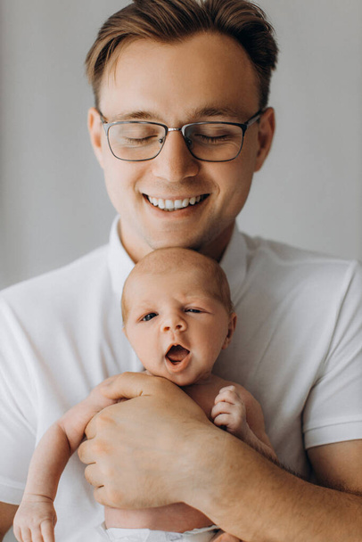 Portrait of handsome man with adorable newborn baby girl, caring dad gently hold little daughter in arms, enjoy tender parenting moments, smiling, fatherhood concept - Foto, Bild