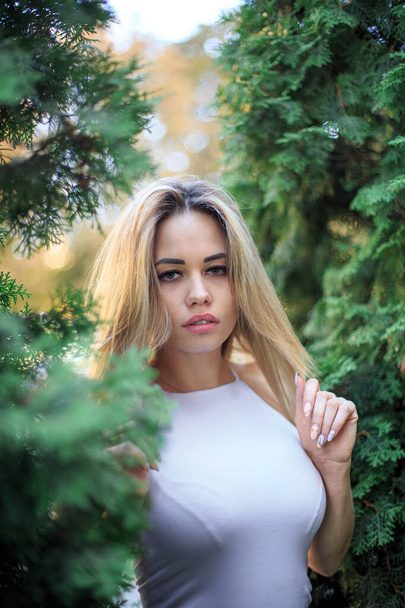 Portrait of a young woman in green trees - Foto, Bild