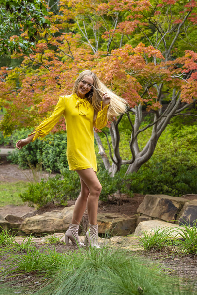 Sonbahar kıyafetleriyle dışarıda poz veren güzel bir sarışın manken. - Fotoğraf, Görsel
