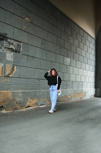Young woman in casual clothes on a wall background - Foto, Bild